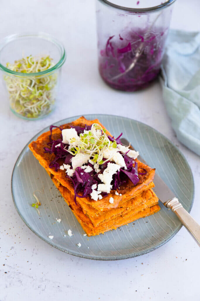 Flatbread mit rotem Cole slaw auf Teller, Sprossen im Hintergrund