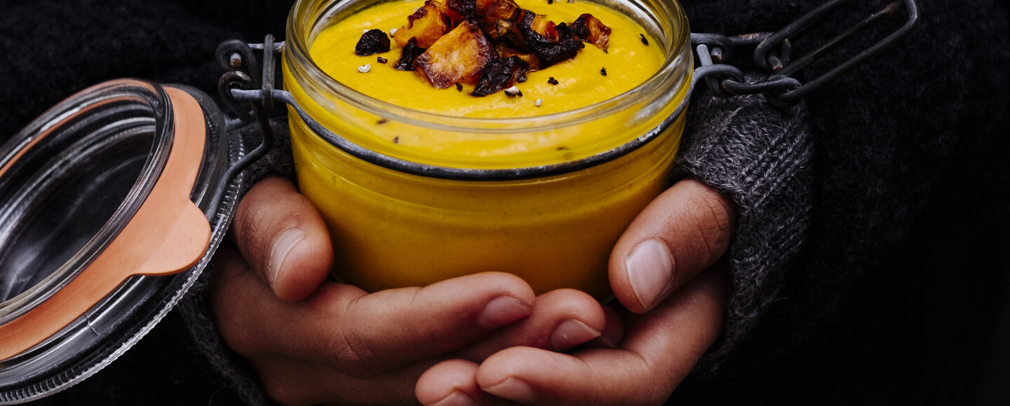 Roasted carrot soup hold in a glas