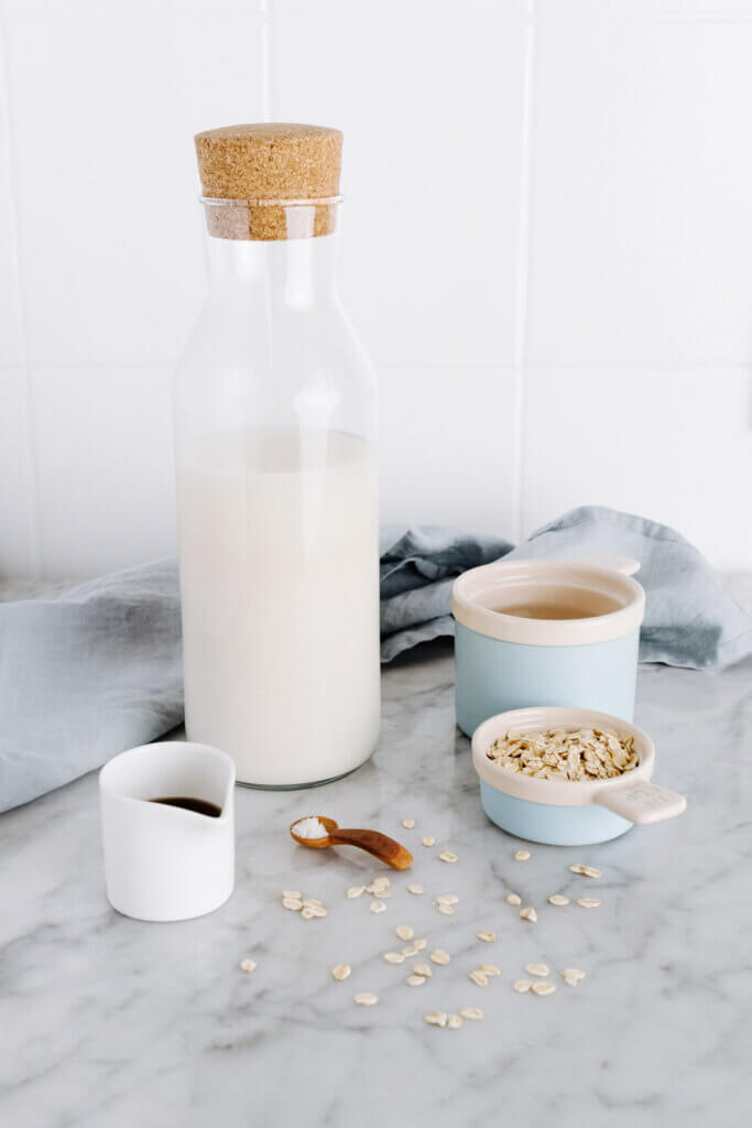 Hafermilch in Flasche und Zutaten