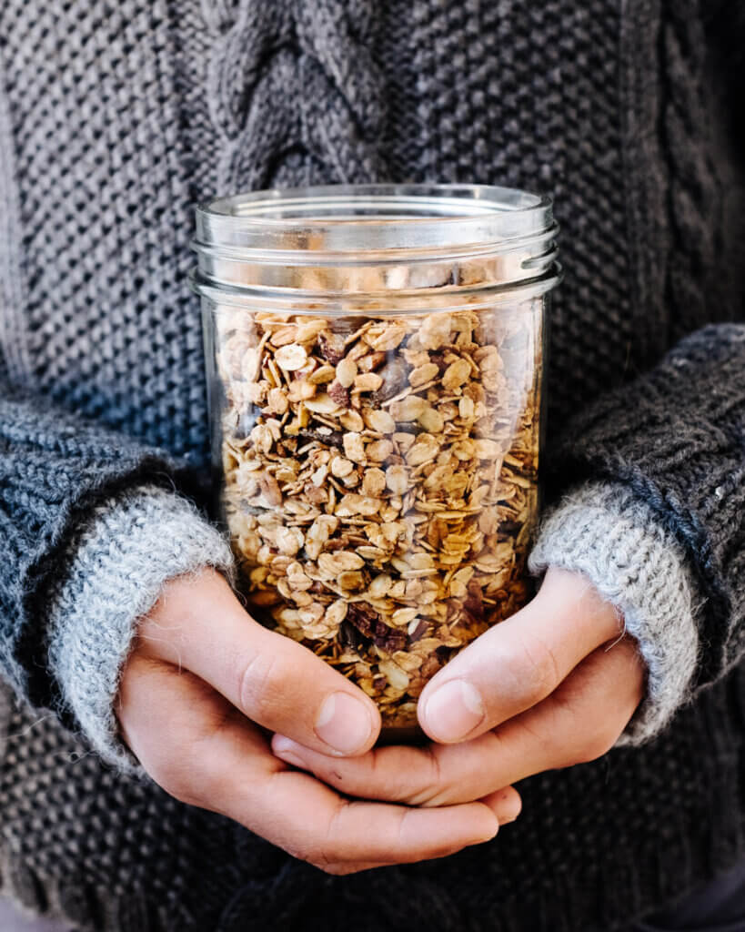 Pumkin Spice Granola in Glas von Hand gehalten