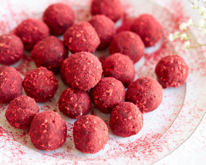 Himbeeren Bliss Balls auf weißem Teller